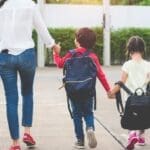 Children walking to school with backpacks.
